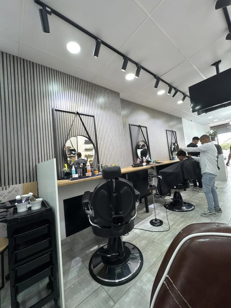 Modern hair salon interior with barber chairs, styling stations with mirrors, and salon staff working with clients