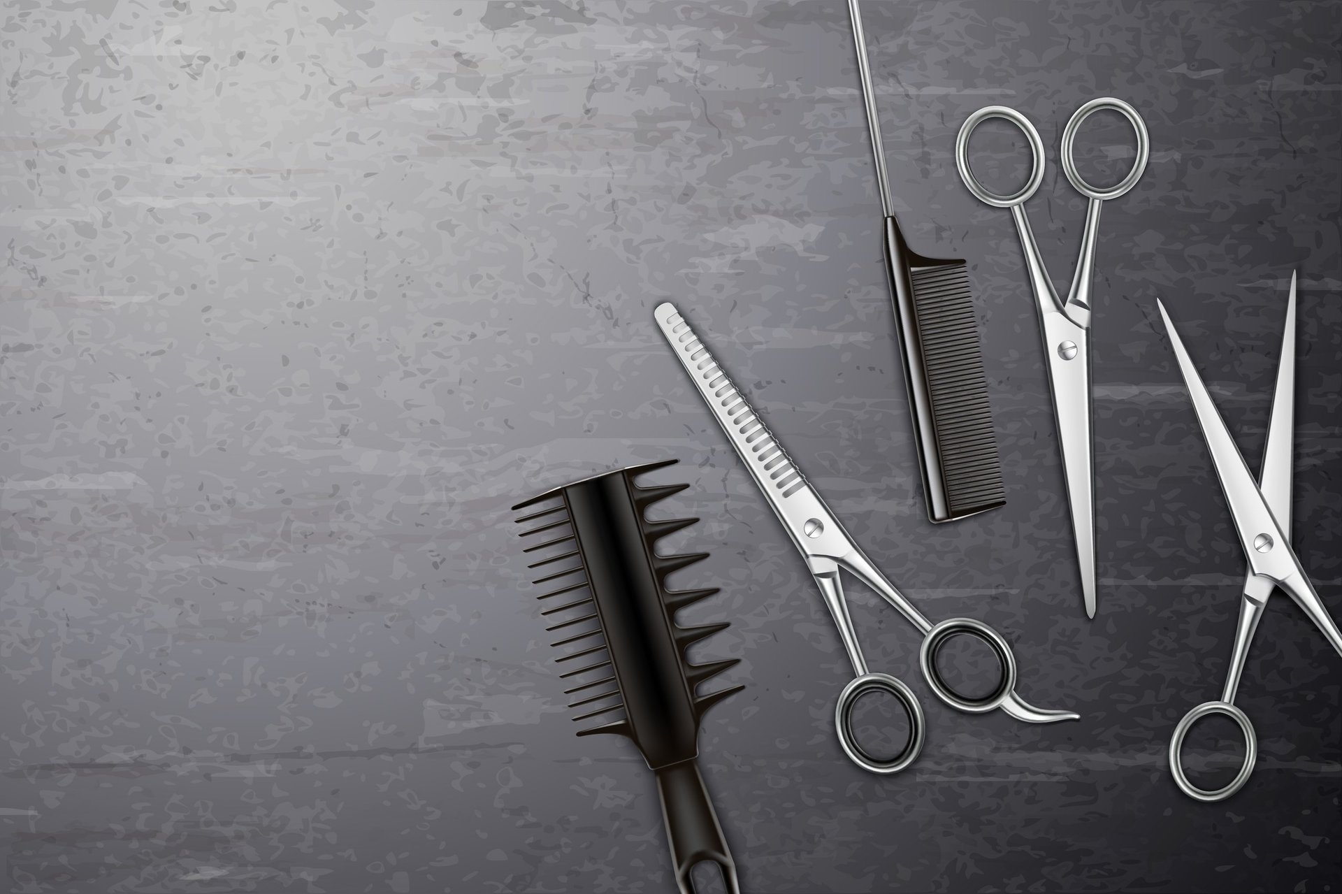 Professional hairstyling tools on gray surface including scissors, combs, and clippers arranged flat lay
